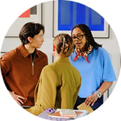 A group of people having a conversation while standing in a room